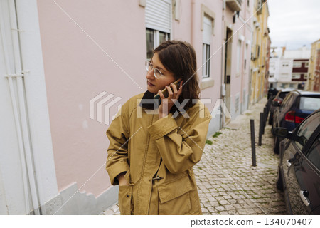 Happy woman communicating, Casual woman on phone outside 134070407