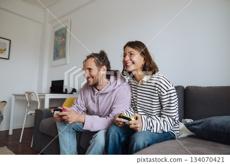 Pair of friends sharing leisure time through casual gaming at home 134070421