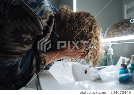 Actor calmly removes makeup and revitalizes skin beside illuminated mirror Actor calmly removes makeup and revitalizes skin beside illuminated mirror 134070449