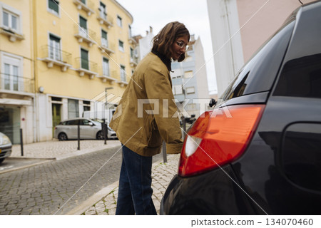 Person organizing travel bags beside colorful city homes Person organizing travel bags beside colorful city homes 134070460