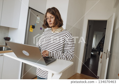 Focused woman analyzing business data on her personal computer Focused woman analyzing business data on her personal computer 134070463