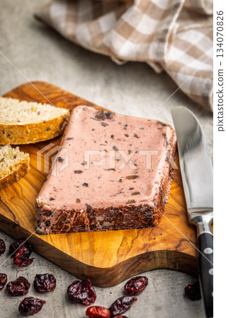 Liver pate with cranberries on wooden cutting board. 134070826