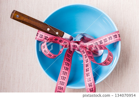 Measuring tape around empty bowl on table Measuring tape around empty bowl on table 134070954