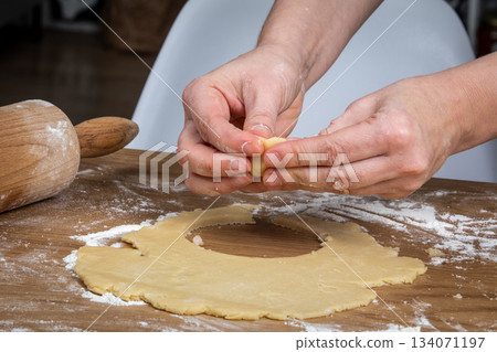 Hands Shaping Filled Dough Into a Small Pastry Ball on Floured Surface Hands Shaping Filled Dough Into a Small Pastry Ball on Floured Surface 134071197