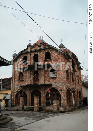 An unfinished brick structure stands on a quiet corner in Sremski Karlovci, Serbia. Its raw texture and open arches highlight an early construction stage An unfinished brick structure stands on a quiet corner in Sremski Karlovci, Serbia. Its raw texture and open arches highlight an early construction stage 134071480
