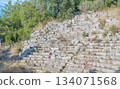Ancient amphitheater ruins at the Ancient City of Phaselis in Tirki, surrounded by trees and rocky terrain, showcasing historical architecture and natural beauty. 134071568
