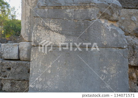 Ancient stone column with inscriptions and hieroglyphs. Antique landmark. Turkey, Kemer, Phaselis 134071571