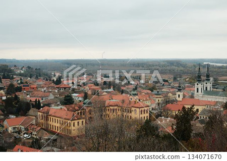 Historic rooftops of Sremski Karlovci with iconic yellow architecture and church towers. The scene conveys heritage, culture, and timeless atmosphere Historic rooftops of Sremski Karlovci with iconic yellow architecture and church towers. The scene conveys heritage, culture, and timeless atmosphere 134071670