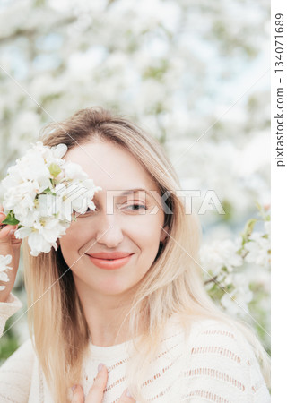 Blonde woman enjoying spring blossoms, peaceful moment in blooming cherry garden, seasonal beauty, floral fashion concept, nature appreciation, feminine serenity, romantic outdoor lifestyle Blonde woman enjoying spring blossoms, peaceful moment in blooming cherry garden, seasonal beauty, floral fashion concept, nature appreciation, feminine serenity, romantic outdoor lifestyle 134071689