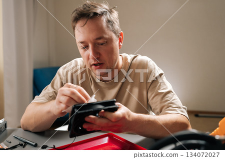 Technician cleaning and maintaining computer liquid cooling system components, ensuring optimal performance and extending hardware lifespan for efficient computing. 134072027