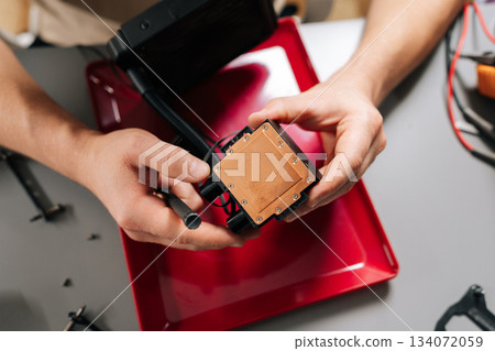 Close-up of technician hands installing liquid cooling system CPU block on computer hardware, performing maintenance, assembly, upgrade of high-performance pc components for better cooling. 134072059