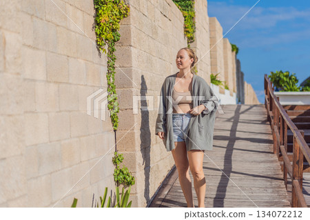 Woman enjoying peaceful time at the beach, relaxing on the sand with ocean views and warm sunlight. Summer leisure, wellbeing and travel concept, representing freedom, calmness and mindful coastal Woman enjoying peaceful time at the beach, relaxing on the sand with ocean views and warm sunlight. Summer leisure, wellbeing and travel concept, representing freedom, calmness and mindful coastal 134072212