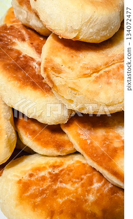 Close up of a pile of traditional homemade golden brown baked or fried pies 134072477