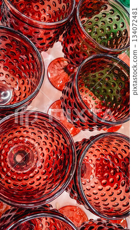 Close up overhead view of vibrant red glass goblets with a textured dimpled pattern Close up overhead view of vibrant red glass goblets with a textured dimpled pattern 134072481