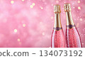 Festive background with Christmas and New Year. Bottle of champagne and sparkles pink background. Celebration banner concept. 134073192
