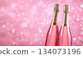 Festive background with Christmas and New Year. Bottle of champagne and sparkles pink background. Celebration banner concept. 134073196