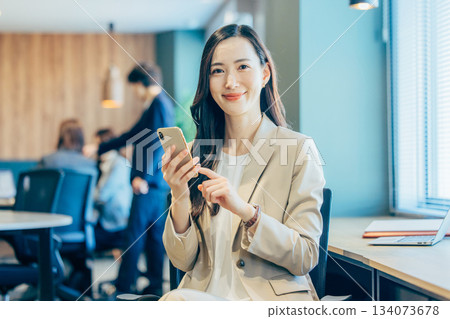 經營一部智能手機的女商人在辦公室 134073678