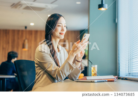 一位女商人正在共享辦公空間查看智慧型手機 134073685