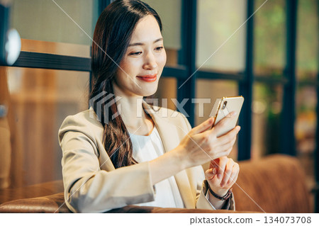 A woman using a smartphone in a cafe 134073708