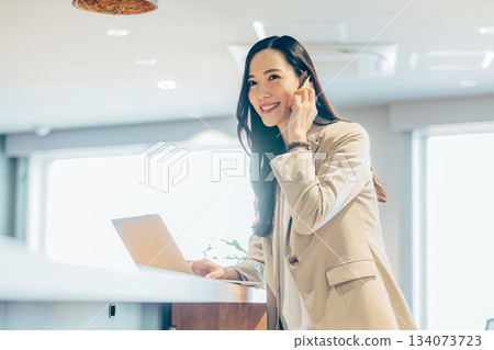 Business woman with a laptop computer in the office Business woman with a laptop computer in the office 134073723