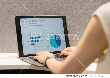 A woman operating a computer in a coworking space 134073733