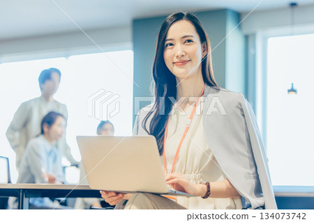 一位女商人正在共享辦公空間使用筆記型電腦。 134073742