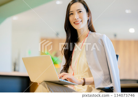 一位女商人正在共享辦公空間使用筆記型電腦。 134073746