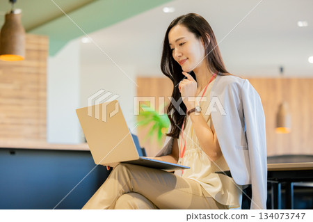 一位女商人正在共享辦公空間使用筆記型電腦。 134073747