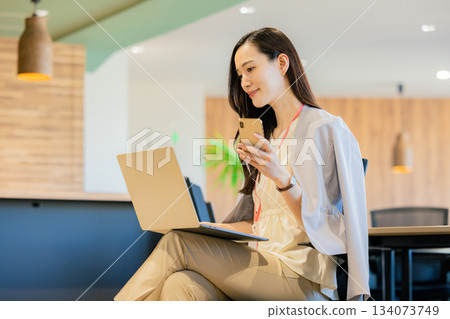 一位女商人正在共享辦公空間使用筆記型電腦。 134073749