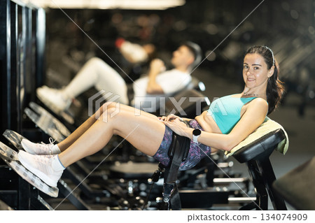 Woman performing hip thrusts on glute bridge machine at gym Woman performing hip thrusts on glute bridge machine at gym 134074909