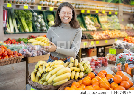 Young woman choosing bananas in vegetable shop Young woman choosing bananas in vegetable shop 134074959