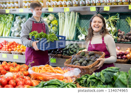 Portrait of female grocery store seller with basket of ripe kiwis in hands 134074965