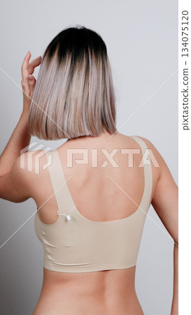 Rear view of a woman in nude underwear with wet hair, showing her back Rear view of a woman in nude underwear with wet hair, showing her back 134075120