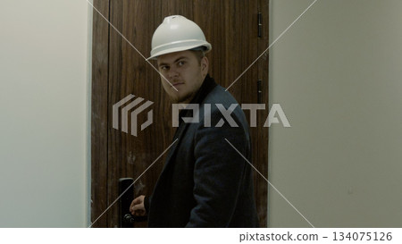 Male engineer or architect walking through the incomplete building interior 134075126