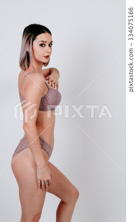 Side profile of a woman in nude lingerie posing with one hand near her head Side profile of a woman in nude lingerie posing with one hand near her head 134075166