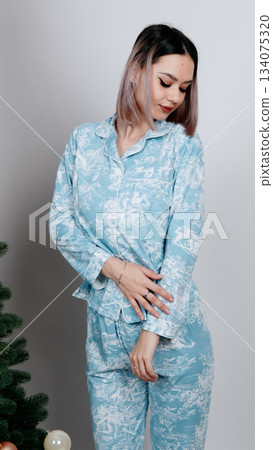 Woman in a gray-beige lace lingerie set posing with hands resting on shoulders. Woman in a gray-beige lace lingerie set posing with hands resting on shoulders. 134075320