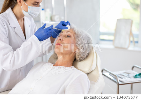 Elderly patient getting forehead fillers Elderly patient getting forehead fillers 134075577