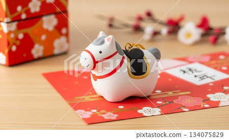 A clay bell figurine of a horse representing the Chinese zodiac and red and white plum blossoms 134075829