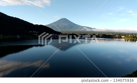 富士山倒映在河口湖中，湖面上泛起漣漪，一艘小船緩緩駛過。 134075916