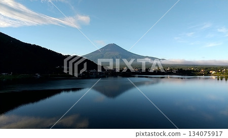富士山倒映在河口湖中,湖面上泛起漣漪,一艘小船緩緩駛過。 富士山倒映在河口湖中,湖面上泛起漣漪,一艘小船緩緩駛過。 134075917