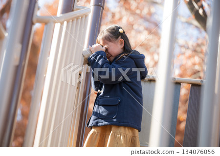 Children playing with playground equipment in an autumn park. Images of children going out and having leisure time in winter. Looking through a telescope. 134076056