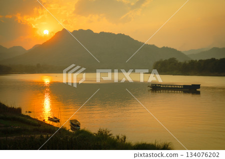 寮國湄公河日落：金色的河水和傳統船隻 134076202
