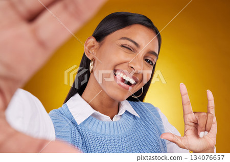 Selfie, rock sign and portrait of Indian woman in studio for happiness, confident and wink on yellow background. Mockup, fashion and girl with punk hand gesture with beauty, cosmetics and makeup Selfie, rock sign and portrait of Indian woman in studio for happiness, confident and wink on yellow background. Mockup, fashion and girl with punk hand gesture with beauty, cosmetics and makeup 134076657