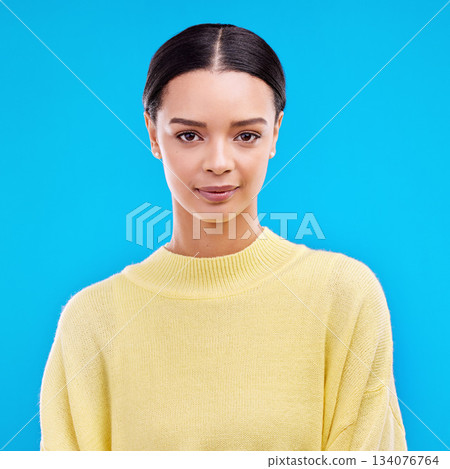 Portrait, serious and woman in studio, relaxed and confident against a blue background. Face, pose and young female smile, relax and standing on isolated space, mockup and indoor product placement Portrait, serious and woman in studio, relaxed and confident against a blue background. Face, pose and young female smile, relax and standing on isolated space, mockup and indoor product placement 134076764