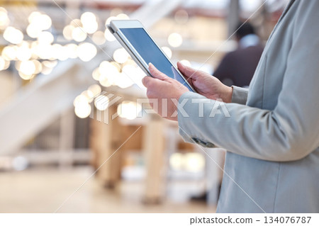 Hands, business and typing on tablet screen in office, social media or research in workplace. Technology, bokeh and professional person or woman browsing online, networking app or internet scrolling. Hands, business and typing on tablet screen in office, social media or research in workplace. Technology, bokeh and professional person or woman browsing online, networking app or internet scrolling. 134076787