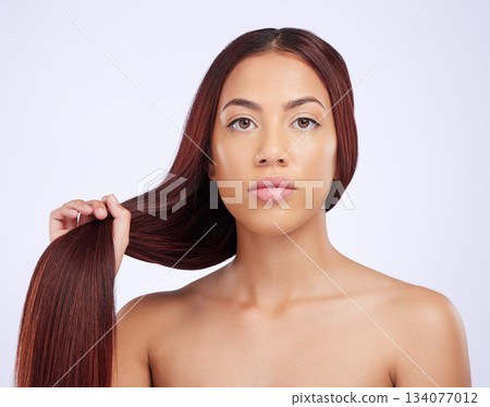 Portrait of woman holding hair, serious beauty and care for straight hairstyle and luxury salon shine on white background. Haircare, haircut and face of Brazilian model with hands on studio backdrop. 134077012