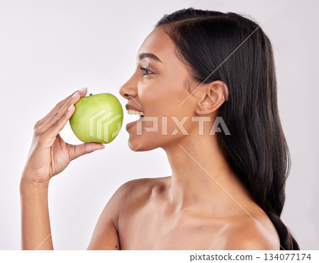 Woman, apple and face profile, health nutrition and fruit with healthy food and detox diet on studio background. Weight loss, organic and fresh produce with happy female mouth, wellness and lifestyle 134077174
