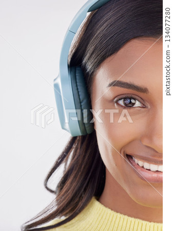 Portrait, headphones and half with a woman in studio on a gray background listening to music. Face, happy and smile with an attractive young female streaming audio using a subscription service Portrait, headphones and half with a woman in studio on a gray background listening to music. Face, happy and smile with an attractive young female streaming audio using a subscription service 134077280