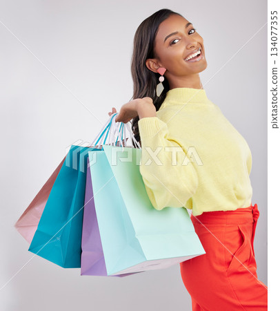 Portrait, shopping and retail with a woman customer in studio on a gray background for a sale or consumerism. Fashion, luxury or bags with a female consumer or shopper carrying bags on her shoulder Portrait, shopping and retail with a woman customer in studio on a gray background for a sale or consumerism. Fashion, luxury or bags with a female consumer or shopper carrying bags on her shoulder 134077355