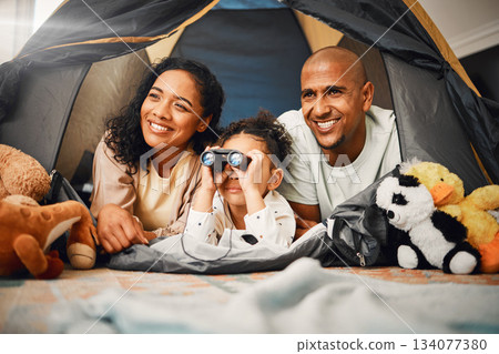 Parents, girl and binoculars in tent, home and smile for games, toys or bonding with love for playing together. Mom, kid and dad with camping game, looking or search in house with happiness on floor Parents, girl and binoculars in tent, home and smile for games, toys or bonding with love for playing together. Mom, kid and dad with camping game, looking or search in house with happiness on floor 134077380